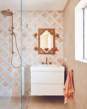 Bathroom with tiled walls, a sink, and a shower.
