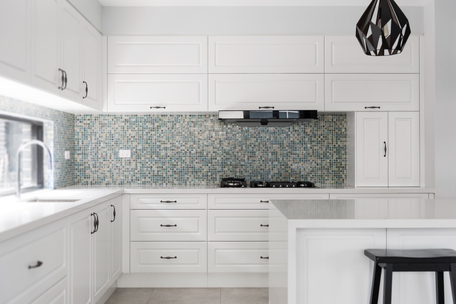 Glass mosaic tile on a kitchen splashback features a dazzling array of small, square glass tiles in a mix of colors and finishes.