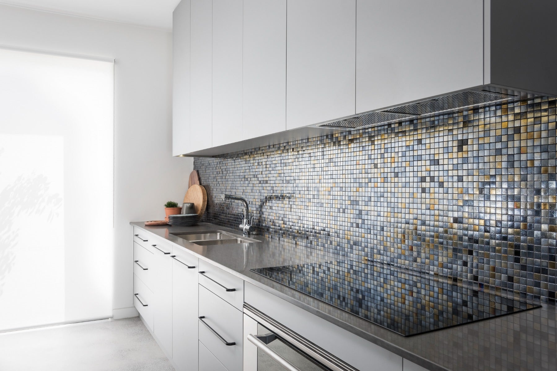 A beautifully designed kitchen splashback featuring intricate mosaic tiles from Amber. The mix of colours and textures in the mosaic creates a stunning focal point, complementing the kitchen's overall design and enhancing the room's aesthetic with a touch of elegance and artistry. purchsed from amber