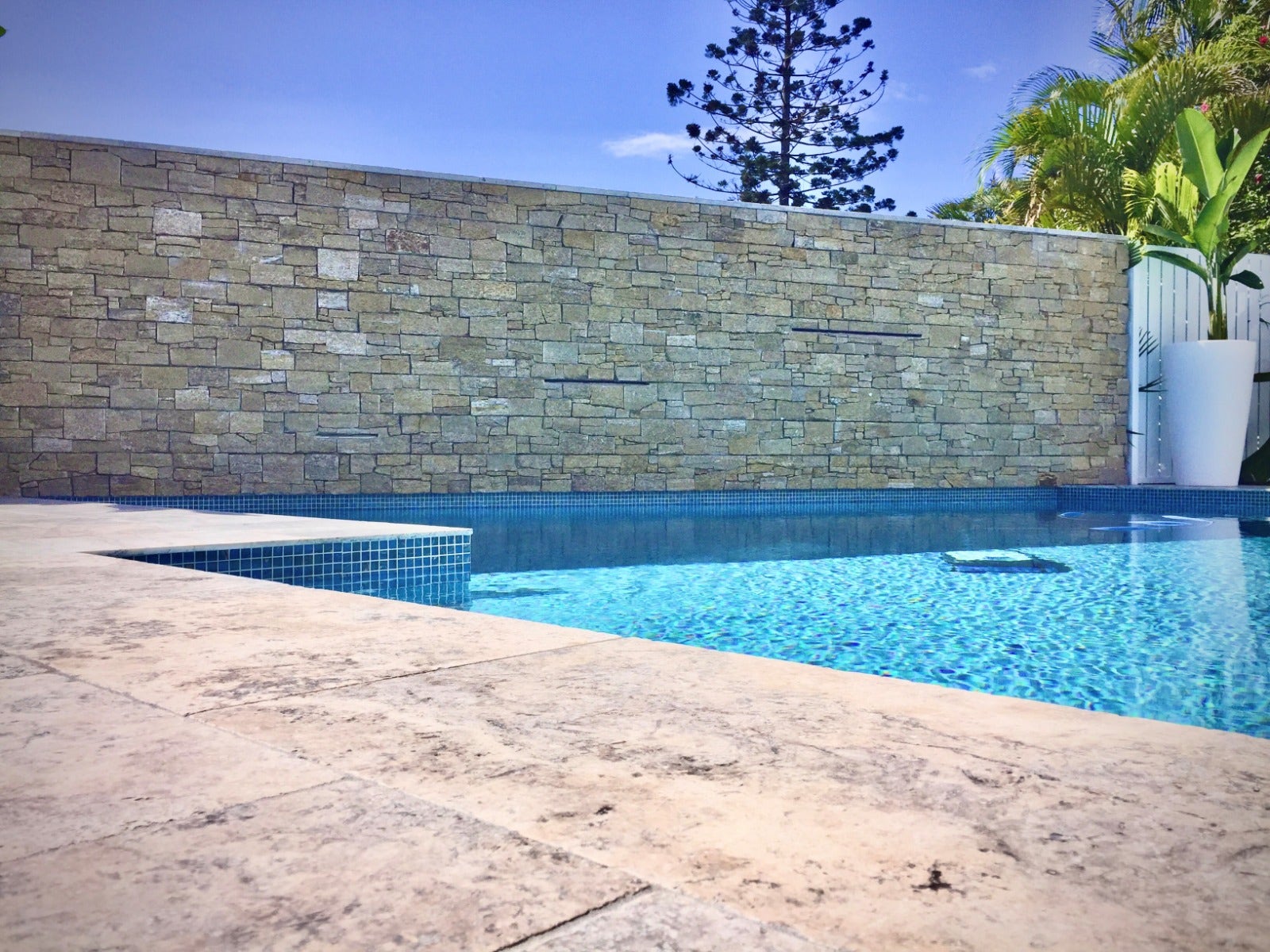 warm earth stone cladding on a pool feature wall from amber