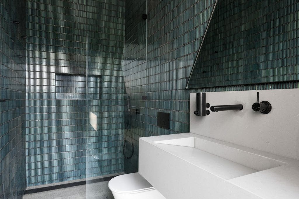 Moody bathroom with green kitkat tiles from amber