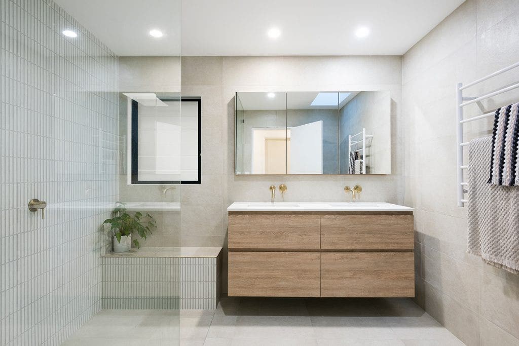 Modern and minimalist bathroom featuring a neutral colour palette with clean lines. This serene space includes a sleek vanity, simple fixtures, and ample natural light, creating a tranquil and uncluttered atmosphere ideal for relaxation