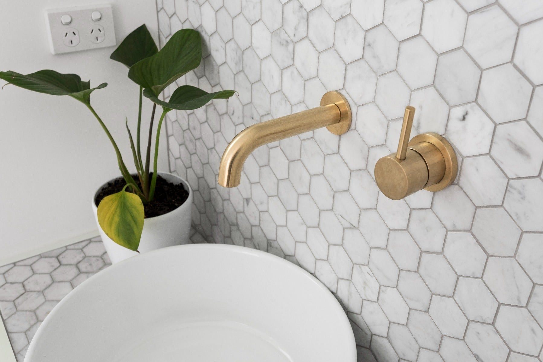 Stunning bathroom design featuring Carrara hexagon mosaic paired with elegant gold tapware. The sophisticated combination of classic white marble hexagons and chic gold accents creates a luxurious and stylish focal point