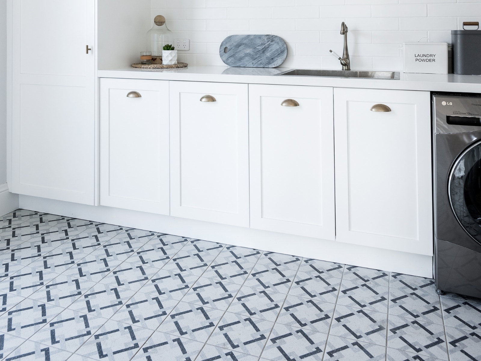hamptons style laundry using blue patterened floor tiles and white subway tiles from amber