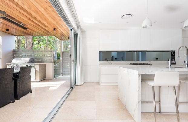 A limestone floor in a kitchen area features natural, light beige tiles with subtle veining