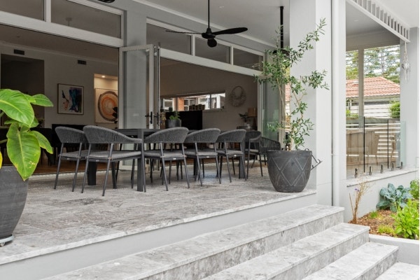 Elegant contemporary alfresco area showcasing luxurious marble pavers from Amber. This stylish outdoor space features a seamless integration of modern design elements with natural stone, providing a sophisticated and inviting setting for outdoor entertaining and relaxation